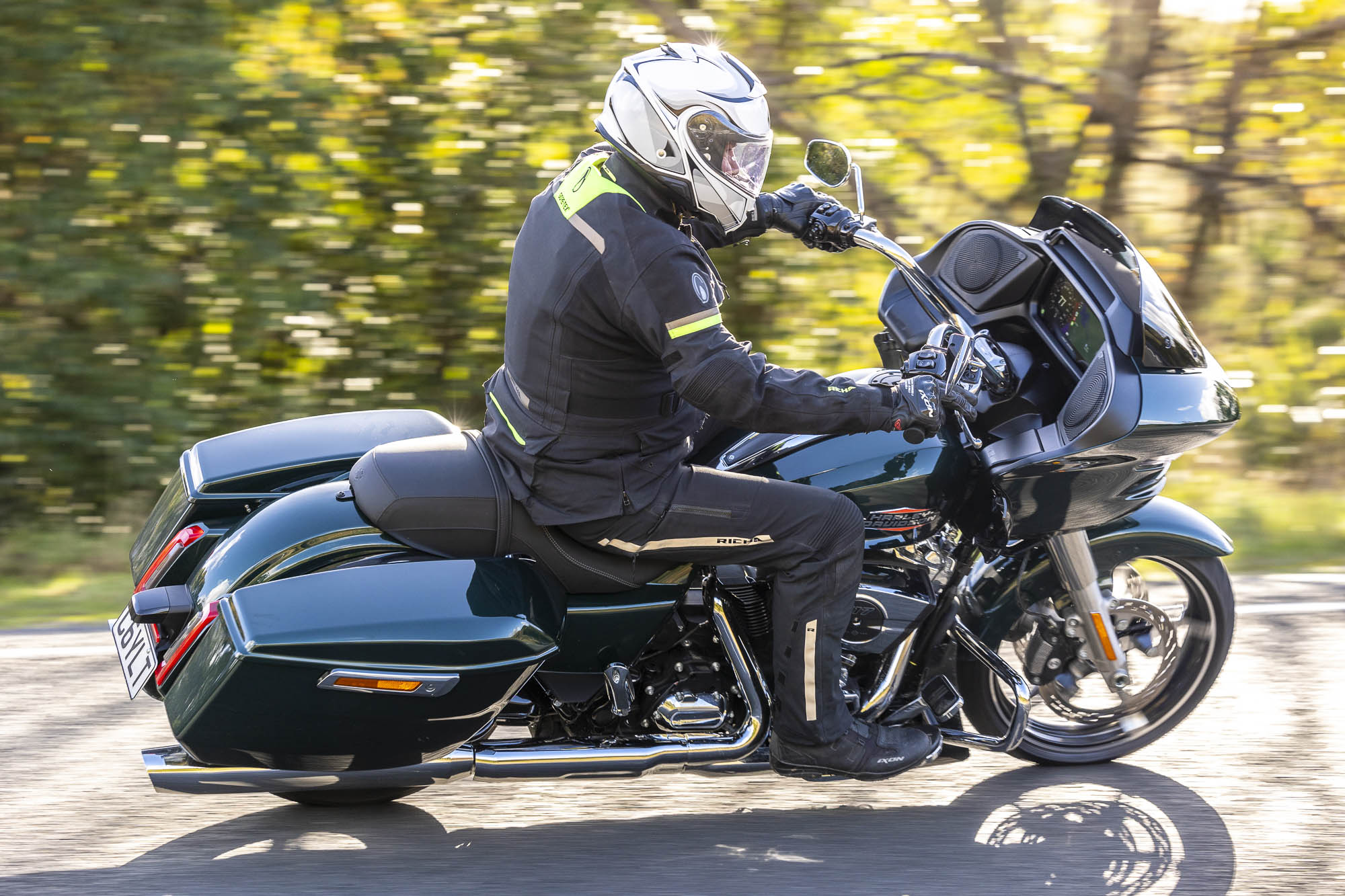 Rider on a Harley-Davidson Road Glide on a tree-lined road