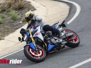 BMW F900XR 2025 touring motorcycle carving through a twisty mountain pass