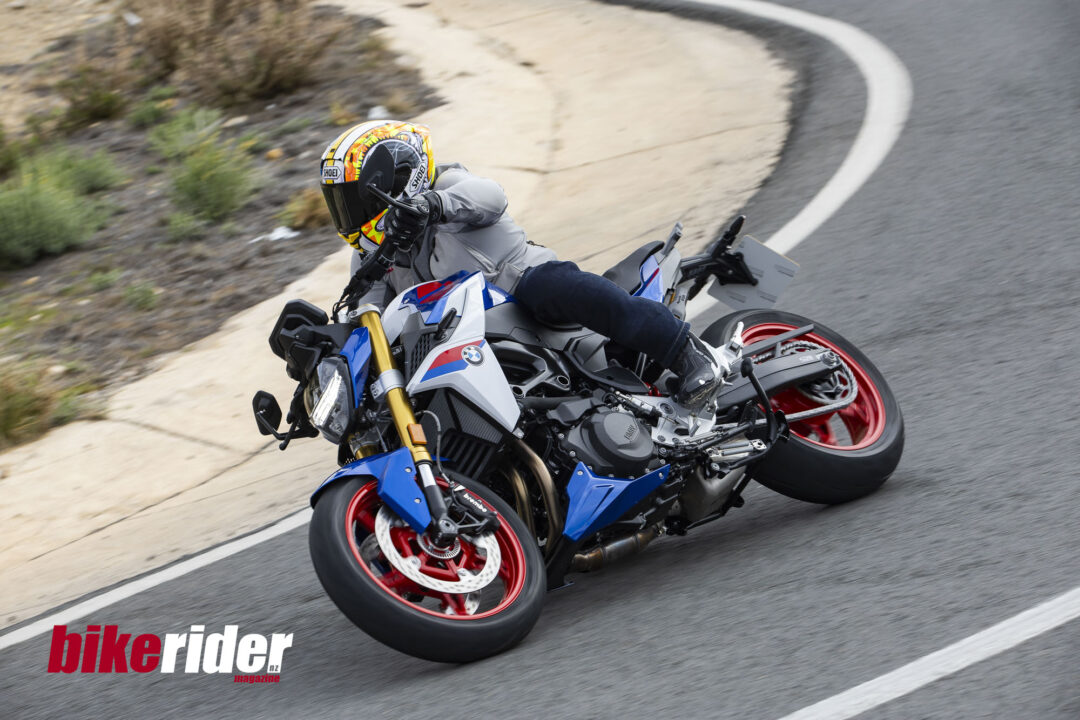 BMW F900XR 2025 touring motorcycle carving through a twisty mountain pass