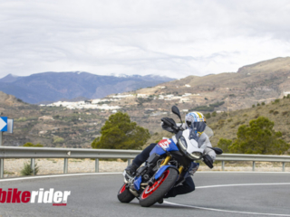 BMW F900XR 2025 touring motorcycle carving through a twisty mountain pass