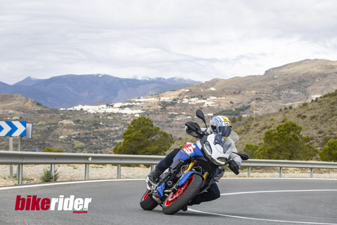 BMW F900XR 2025 touring motorcycle carving through a twisty mountain pass