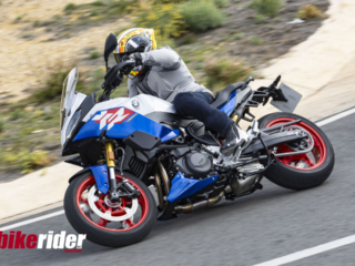 BMW F900XR 2025 touring motorcycle carving through a twisty mountain pass