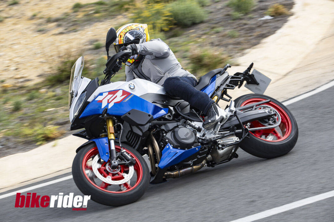 BMW F900XR 2025 touring motorcycle carving through a twisty mountain pass