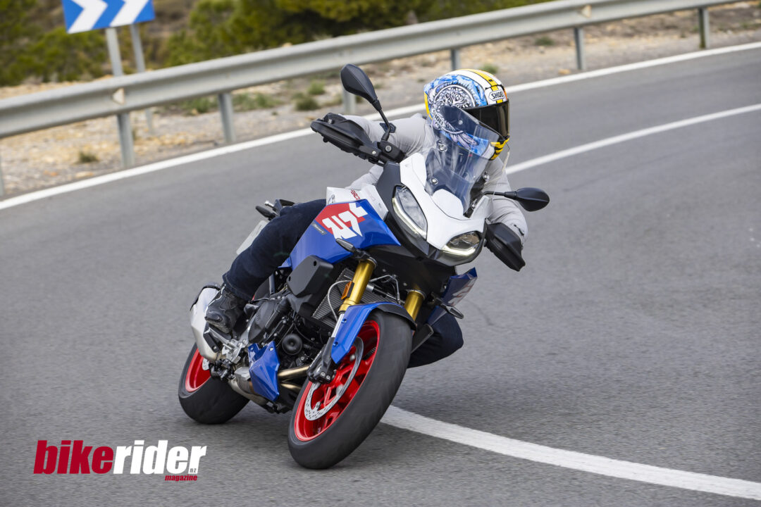 BMW F900XR 2025 touring motorcycle carving through a twisty mountain pass