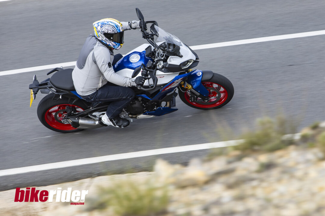 BMW F900XR 2025 touring motorcycle carving through a twisty mountain pass