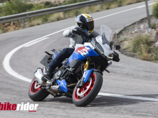 BMW F900XR 2025 touring motorcycle carving through a twisty mountain pass