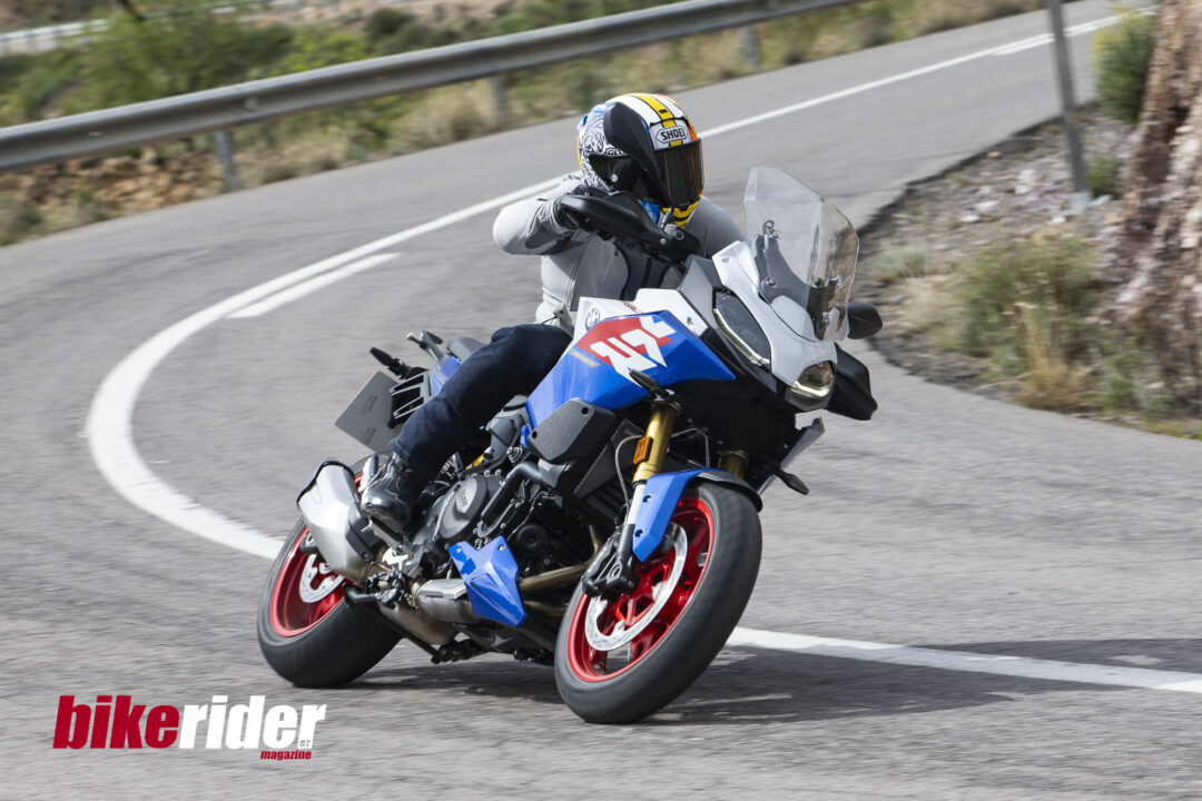 BMW F900XR 2025 touring motorcycle carving through a twisty mountain pass