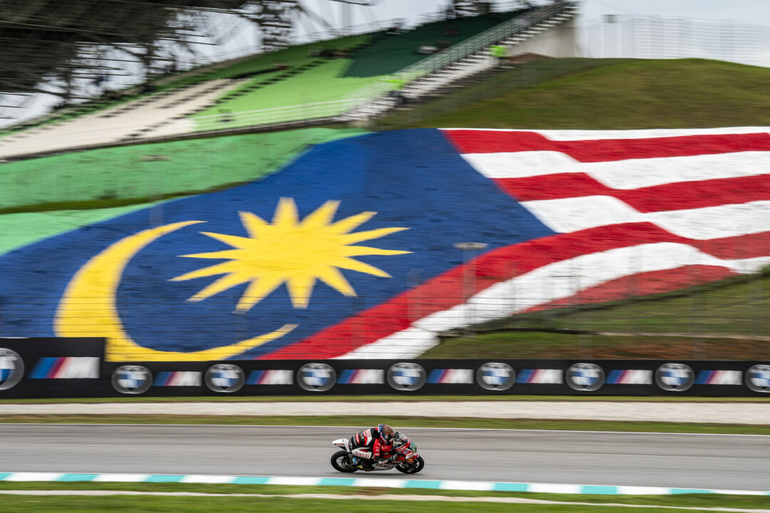 Cormac Buchanan leans into a corner on his Denssi BOE Motorsports Moto3 bike during the Malaysian Grand Prix at Sepang International Circuit. The Southland rider is wearing his blue and red race leathers under the blazing tropical heat.
