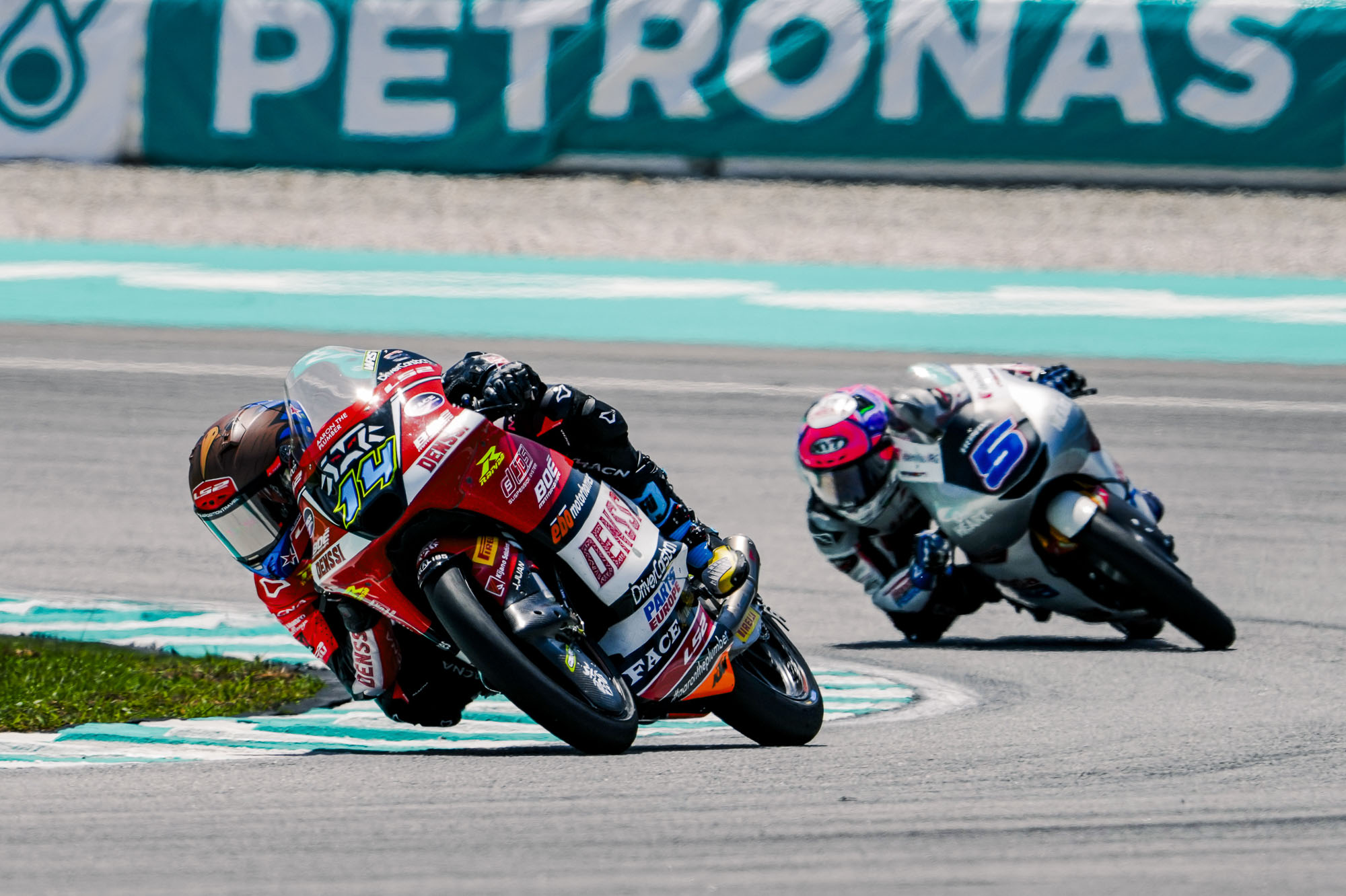 Cormac Buchanan leans into a corner on his Denssi BOE Motorsports Moto3 bike during the Malaysian Grand Prix at Sepang International Circuit. The Southland rider is wearing his blue and red race leathers under the blazing tropical heat.