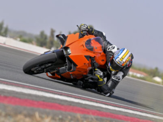 KTM 990 RC R on track at Seville Circuit, leaned over at full pace, elbow down showing the dramatic lean angles acheivable by the new model