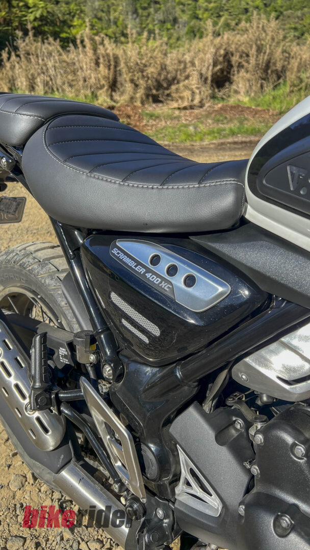 Triumph Scrambler 400XC side panel parked on gravel