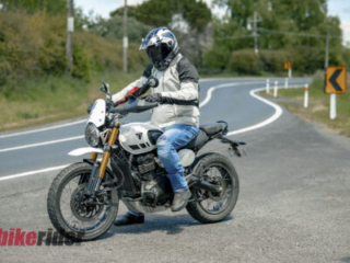 Triumph Scrambler 400XC parked next to winding road