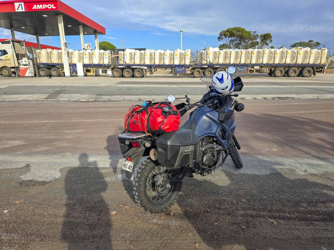 Neurological Research NZ Lap of Oz Kawasaki KLR650 parked by road train