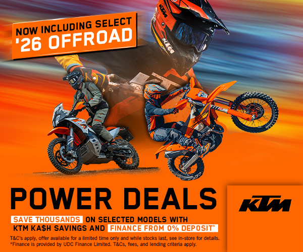 KTM Power Deals advertisement with an orange background, a dirt bike rider performing a wheelie, bold 'POWER DEALS' text, a banner reading 'NOW INCLUDING SELECT 26 OFFROAD', and the KTM logo with savings offers.