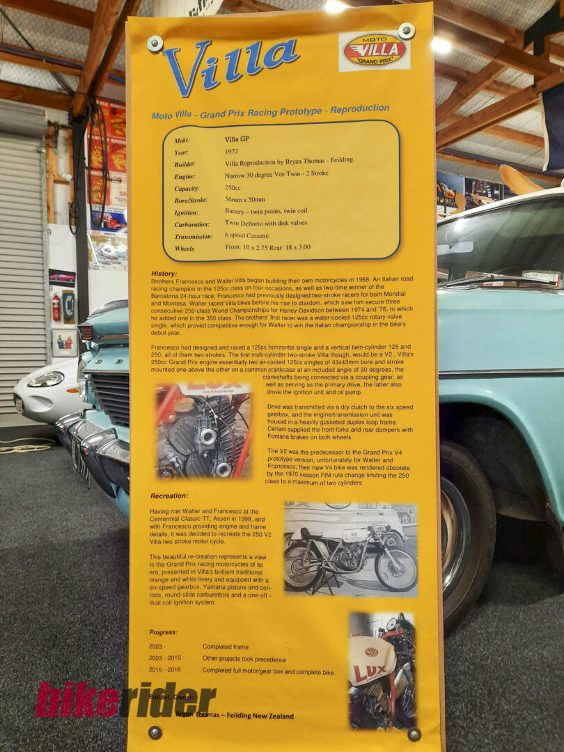 Orange information board detailing the Villa GP racing prototype with a specs box and history text, set in a workshop beside a teal car.