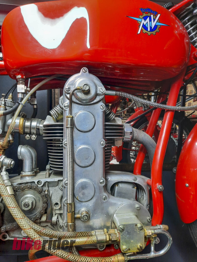 Red motorcycle fuel tank and engine close-up with MV Agusta logo visible on the tank surface