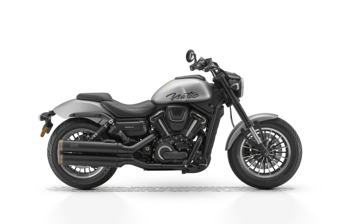 Side view of a silver and black cruiser motorcycle, showing the V-twin engine, exhaust, and front headlight.