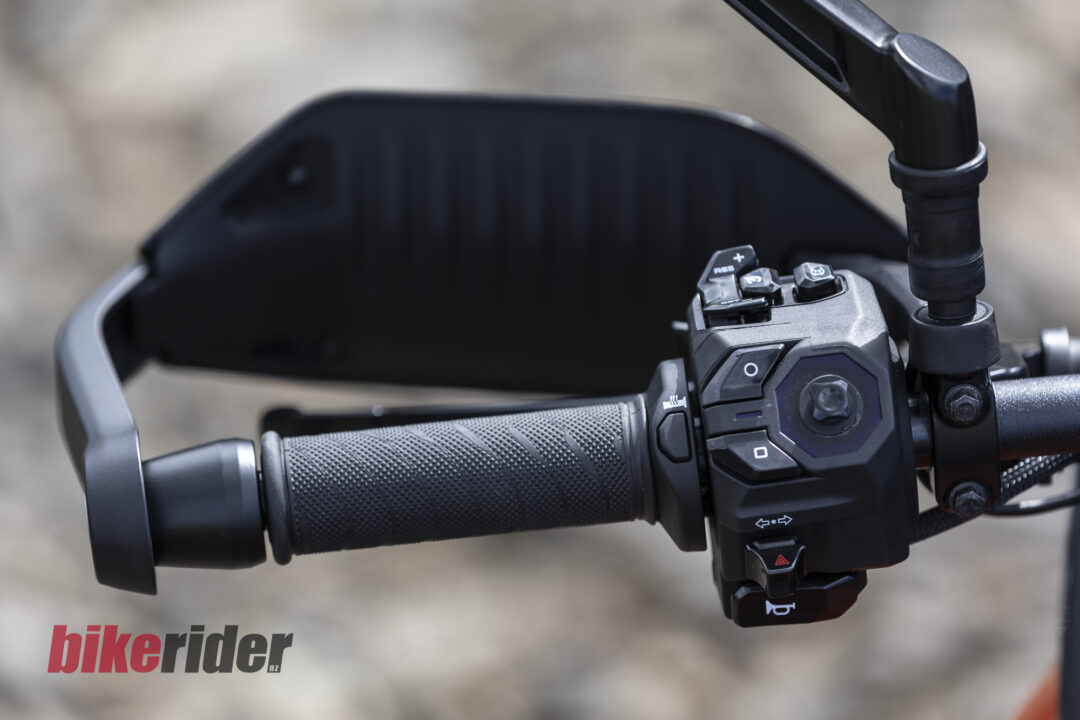 Close-up of a motorcycle right handlebar showing the textured grip and multiple control switches