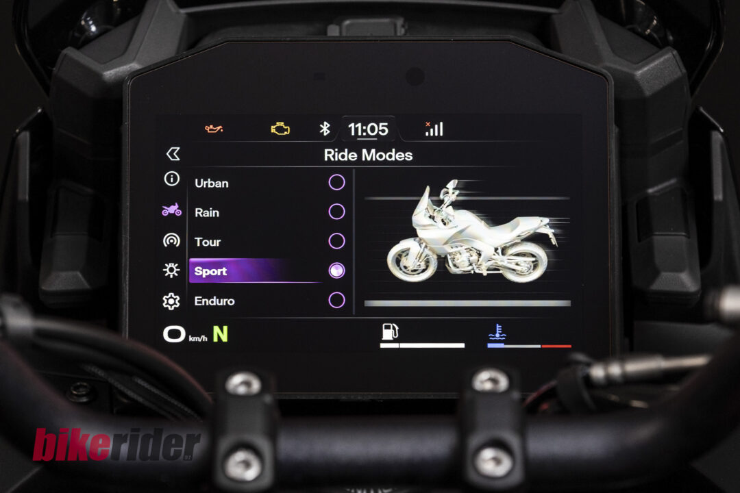 Motorcycle dashboard UI showing the Ride Modes menu (Urban, Rain, Tour, Sport, Enduro) with a motorcycle illustration on the right. Sport mode selected.
