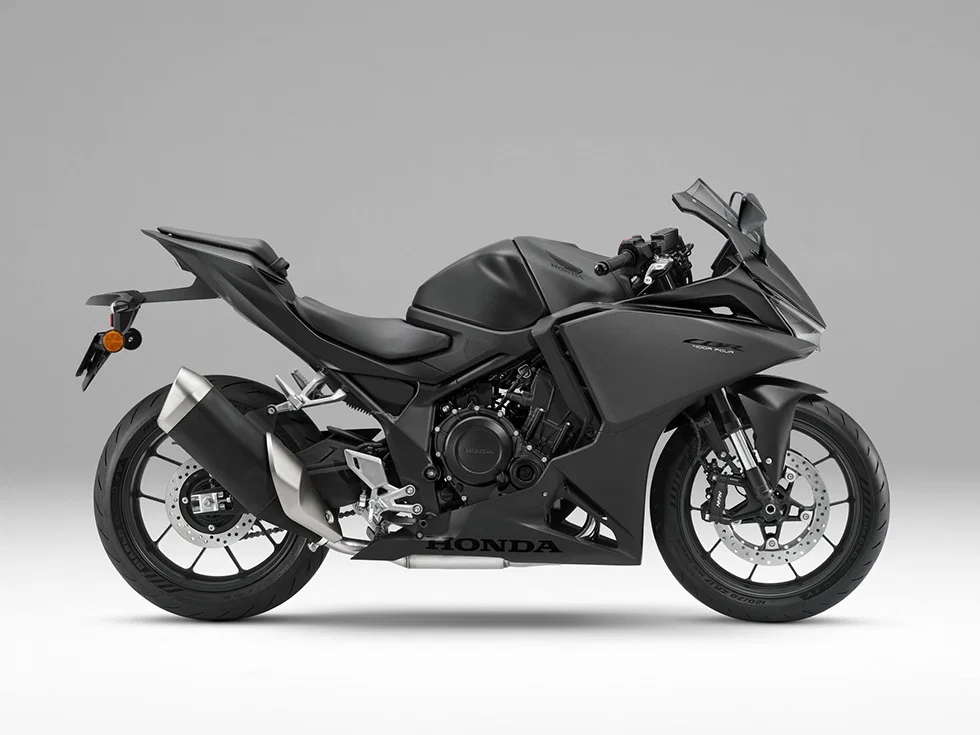 Side view of a matte black Honda sport motorcycle with full fairing and disc brakes.