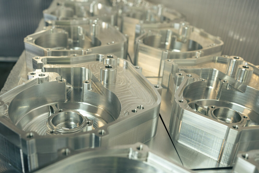 Brough-superior-rmb-01-17 Industrial aluminum molds with circular cavities arranged on a reflective work surface in a metalworking facility