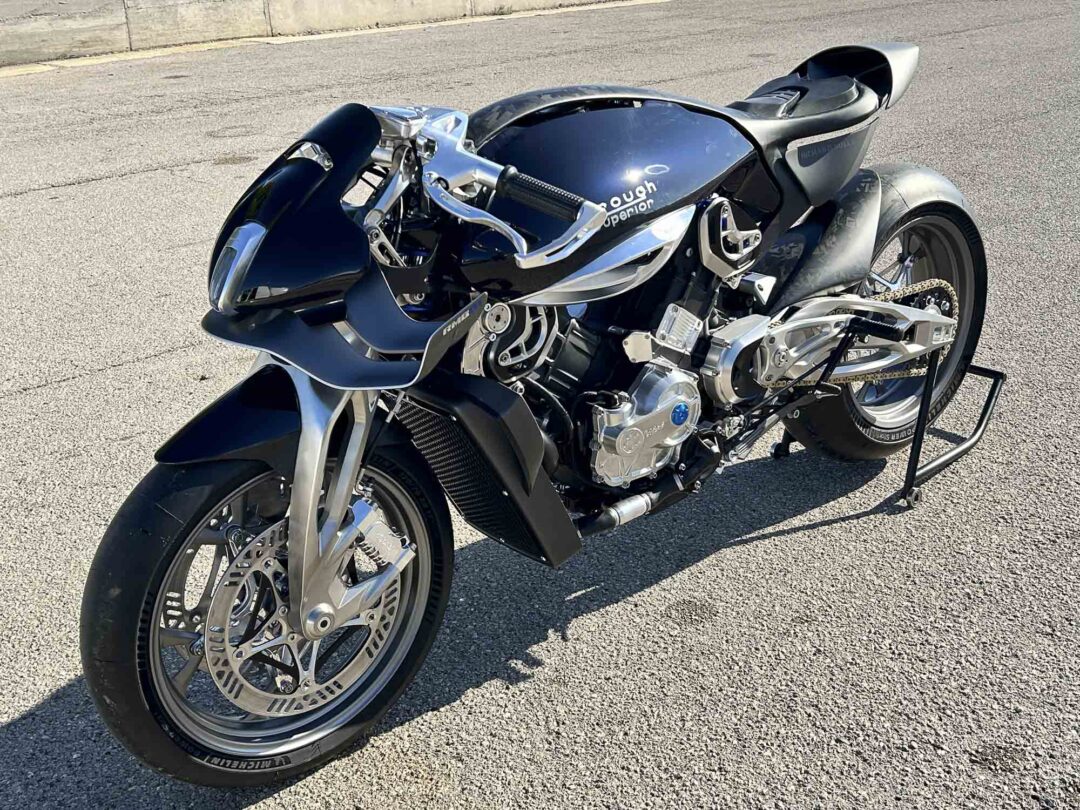 Brough-superior-rmb-01-3-2 Black sport motorcycle with chrome frame and exposed engine parked on an asphalt surface (front wheel and handlebars visible). Give context for a high-performance bike.