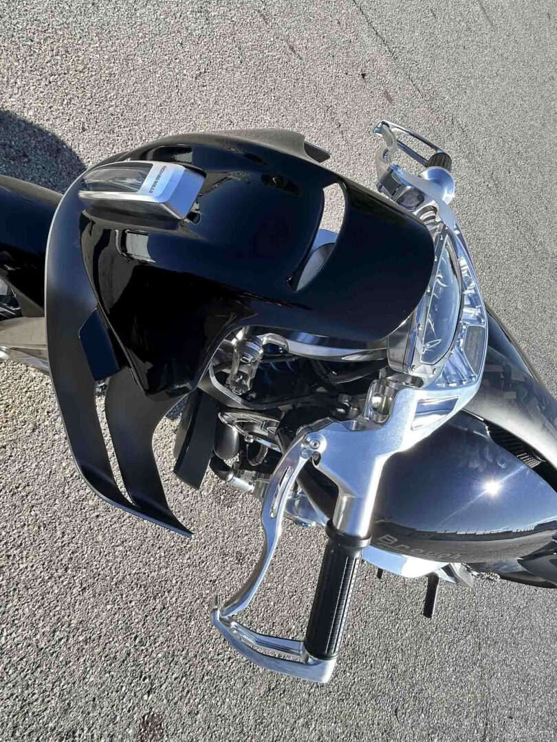 Brough-superior-rmb-01-5-2 Motorcycle with damaged front fairing and exposed handlebars on a gravel surface, viewed from above