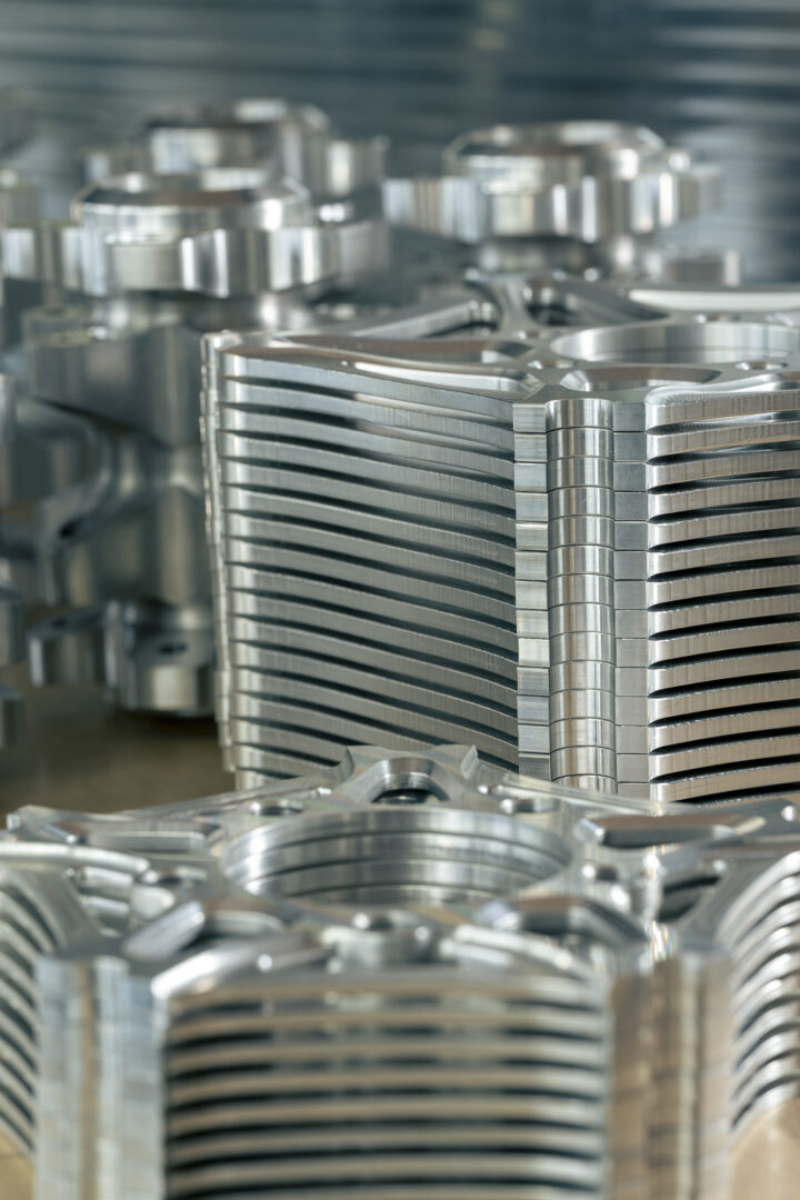 Brough-superior-rmb-01-9-1 Stacks of shiny metal circular spacers with grooved edges in a machining workshop.