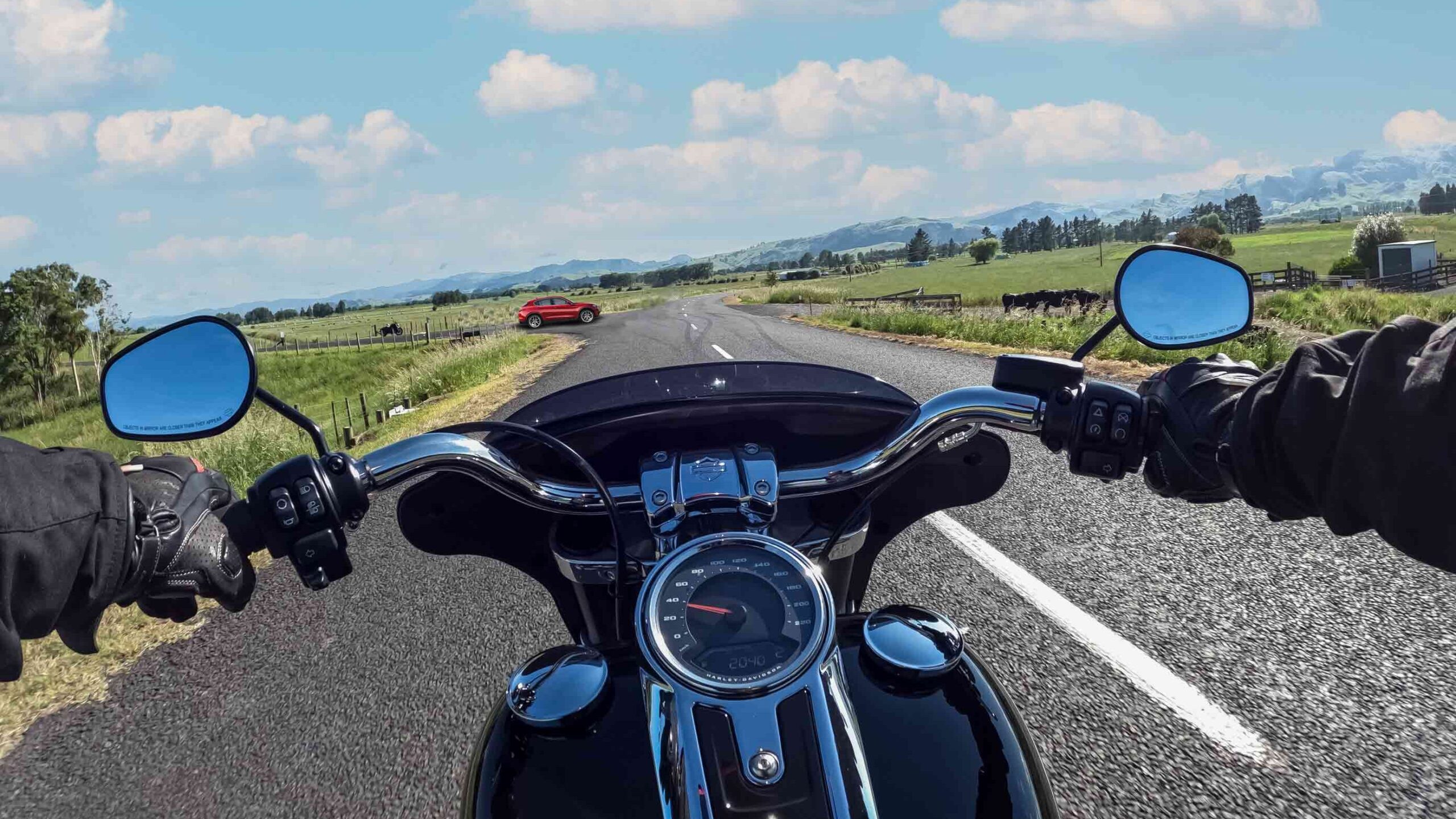 Harley-Davidson Road Glide riding on a road with a car about to pull out from an intersection