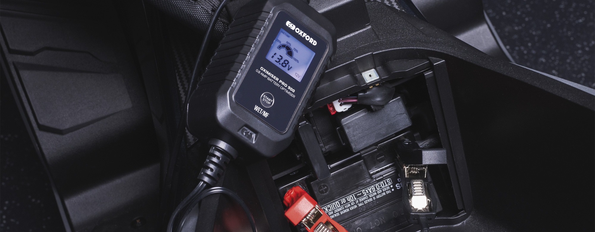 Oxford Oximiser Pro 900 beside a motorcycle battery