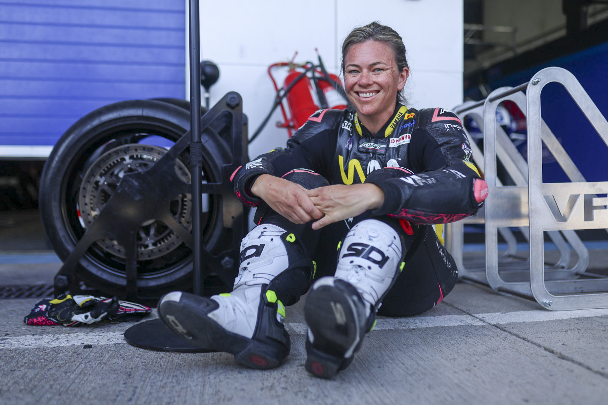 Avalon Lewis smiling in the Jerez paddock wearing Carl Cox Motorsport racing leathers