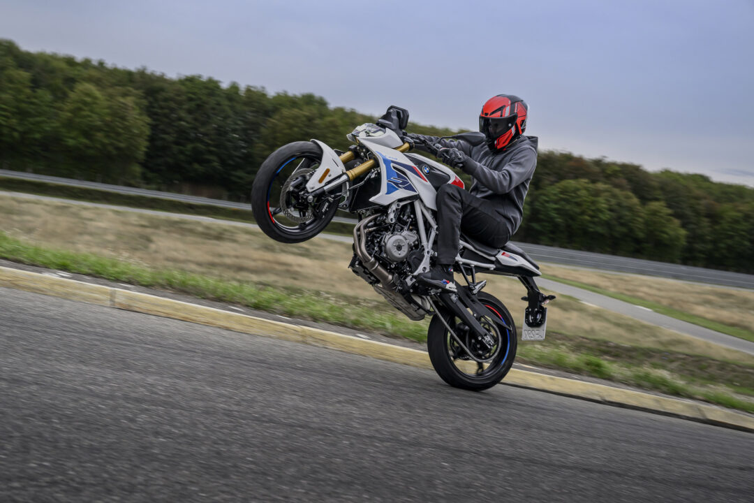 BMW F 450 R rider performing a wheelie