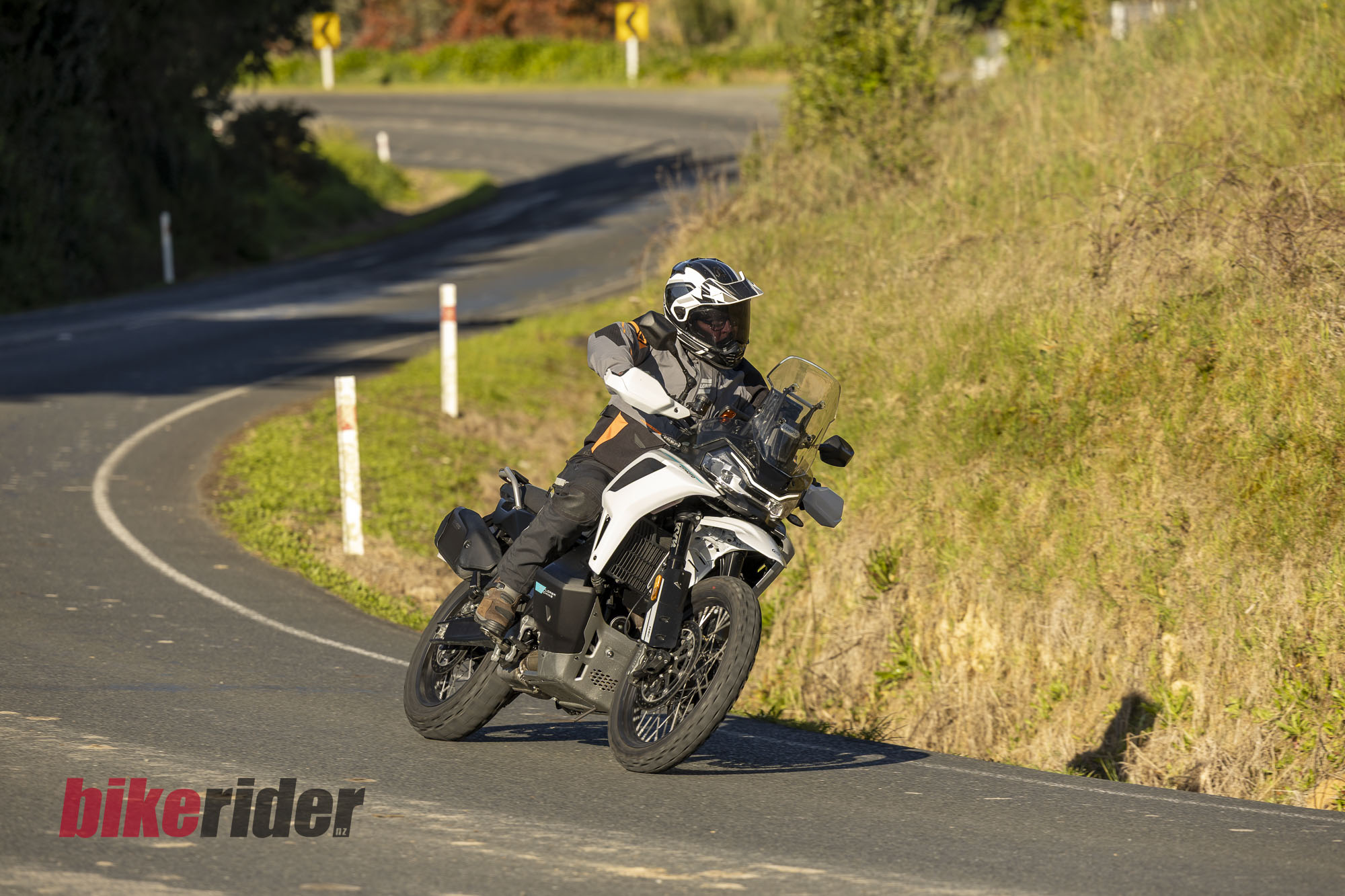 CFMOTO 1000MT-X adventure bike leaning into a bend on a winding sealed road