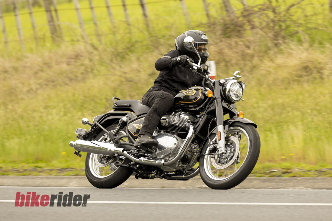 Royal Enfield Bullet 650 in Cannon Black: rider cornering beside a fence