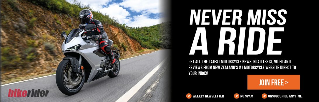 Motorcycle rider on a silver sport bike on a winding road, with a bold 'Never Miss A Ride' ad on the right and a 'Join Free' button.